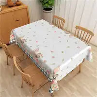 Floral patterned tablecloth with blue striped trim and tassels on the edges.