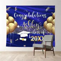 Graduation backdrop banner with ’Congratulations’ text, gold balloons, and a graduation cap design in navy blue and gold colors.