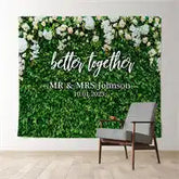 Green leaf wall backdrop with white text reading ’better together Mr & Mrs Johnson’