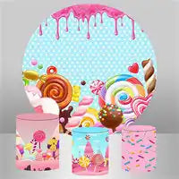 Candy-themed party supplies featuring plates and boxes decorated with lollipops, swirls, and dripping pink frosting.
