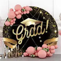 Decorative graduation-themed circular display with ’Grad!’ text, gold accents, and pink balloon garland.