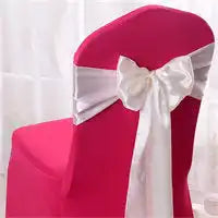 Hot pink chair with a white satin bow tied around its back.
